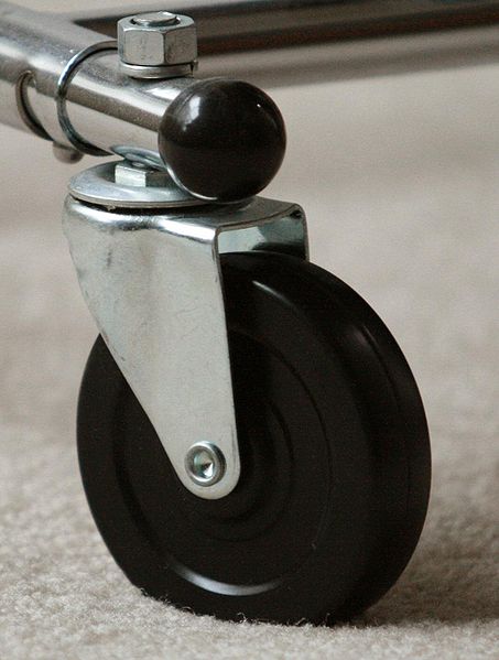  A swivel caster. This caster employs a solid, hard rubber wheel. It is used on a rolling clothing rack. 